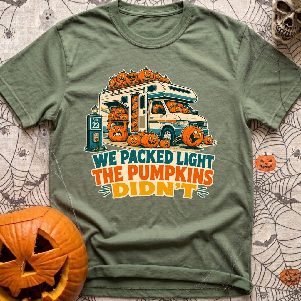 Packed Light Except Pumpkins - T-Shirt in Moss - A cartoon motorhome parked at a campsite hookup labeled "Site 23",...