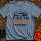 Lifetime Weekend Build - T-Shirt in Blue Jean - A circular graphic showing a white camper van parked near pine trees and...